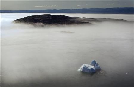 在加拿大北極地區努勒維特的弗羅比舍灣,一個大的冰山在早晨的霧中浮現(2009.8.21, REUTERS/Andy Clark)