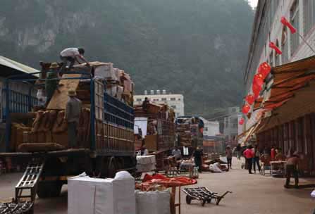 運載大紅酸枝傢俱半成品和原材料的卡車車隊在中國境內的浦寨紅木市場裝貨